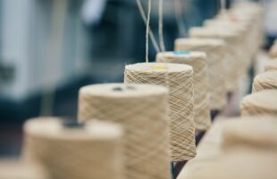 紡績工場で糸が巻き取られている